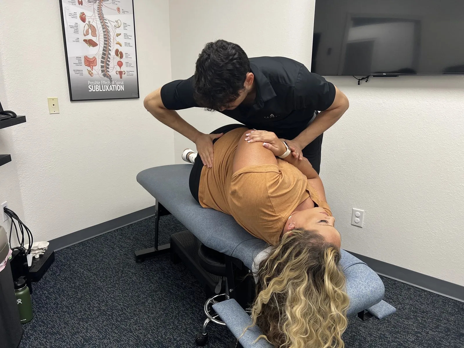 Chiropractor adjusting a patient's lower back in Burleson, TX