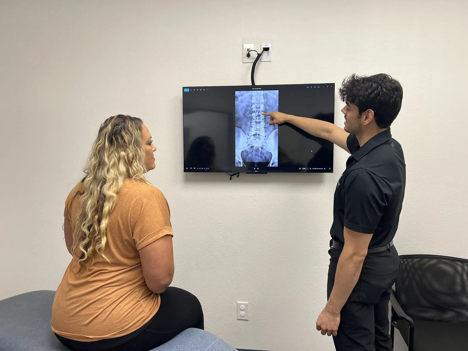 Chiropractor reviewing a spinal X-ray with a patient in Burleson, TX